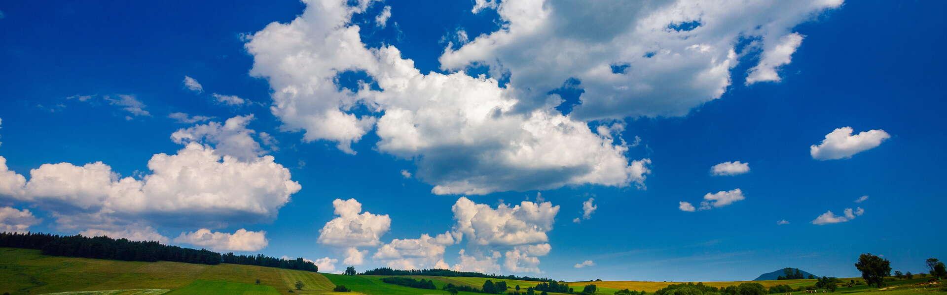 Grüne Felder in den Niederen Beskiden unter blauem Himmel